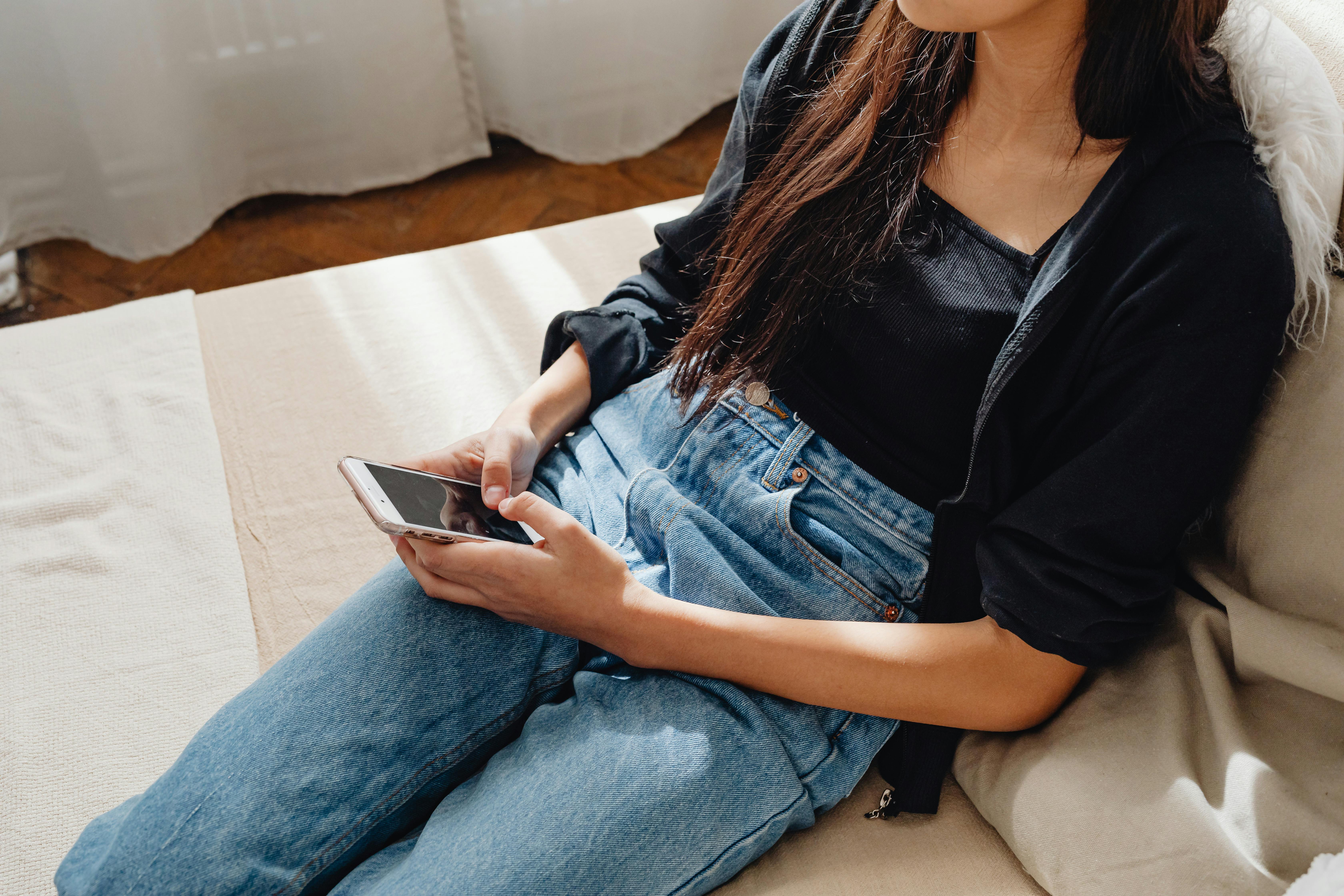 Woman using smartphone on a sofa